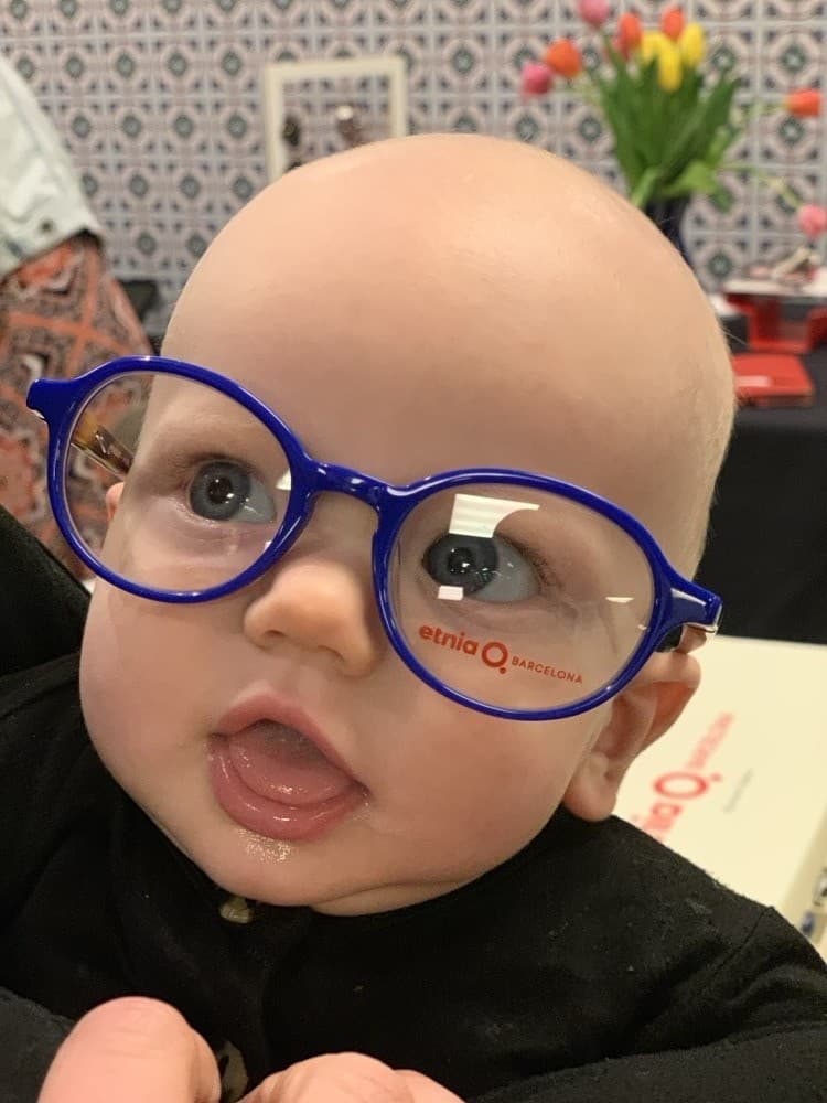 Adorable baby trying on Etnia Barcelona frames at Blinc Eyecare